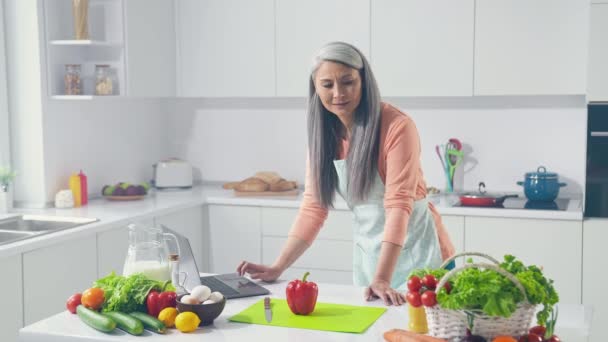 Εστιασμένη κυρία χρησιμοποιούν netbook εργαστήριο μαγειρικής ελέγχουν τα λαχανικά σκέφτονται στην κουζίνα — Αρχείο Βίντεο