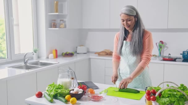 Cool lady hacer la cena pérdida de peso escuchar pop auriculares corte calabacín en la cocina — Vídeos de Stock