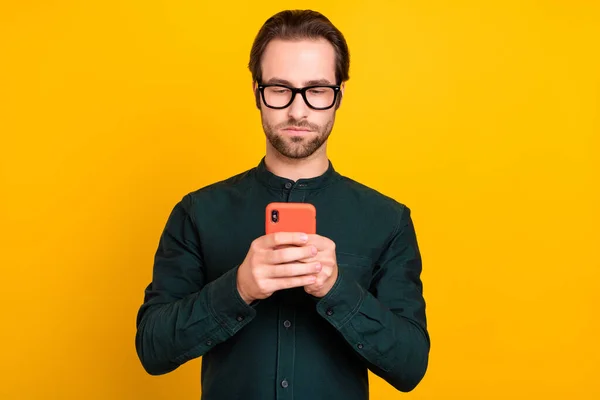 真剣に自信を持って若い男の写真は、スマートカジュアル服のメガネは、現代的なデバイスをチャット黄色の背景を隔離 — ストック写真