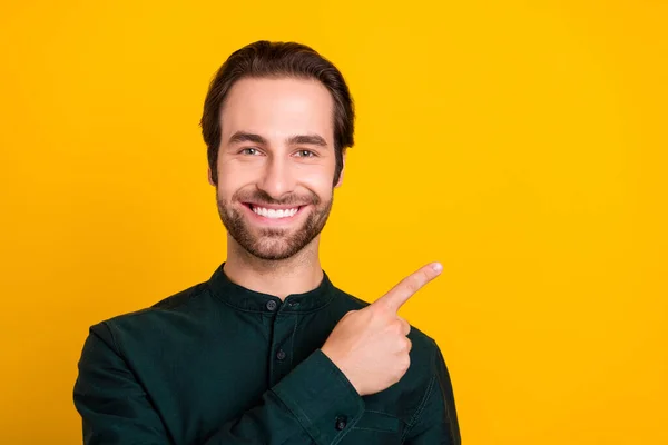 Foto von charmanten netten jungen Mann tragen Smart Casual Outfit zeigt mit dem Finger leeren Raum lächelnd isoliert gelbe Farbe Hintergrund — Stockfoto