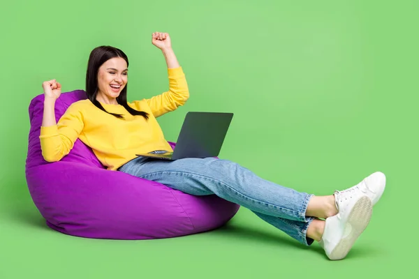 Tampilan ukuran tubuh penuh dari gadis beruntung yang menarik duduk di dalam tas menggunakan laptop bersukacita terisolasi di atas latar belakang warna hijau — Stok Foto