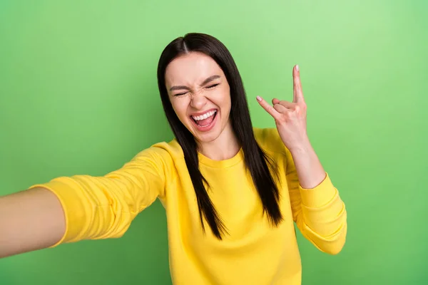 Zdjęcie portret kobiety pokazując heavy metal gest biorąc selfie uśmiecha się odizolowany na jasnozielonym tle koloru — Zdjęcie stockowe