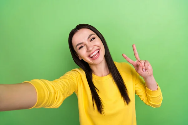 Kuva muotokuva nainen osoittaa rauhaa v-merkki ottaen selfie hymyillen eristetty elinvoimainen vihreä väri tausta — kuvapankkivalokuva