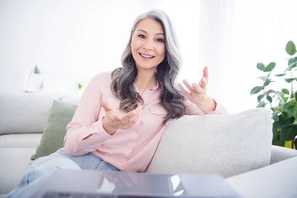 Фото літньої жінки щаслива позитивна посмішка розмова розмова відео виклик ноутбука сидить диван в приміщенні самоізоляція — стокове фото