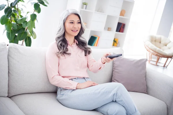 Profilseite Foto von älteren Frau glücklich positives Lächeln sitzen Sofa zu Hause sehen Film Switch Kanal Selbstisolation — Stockfoto