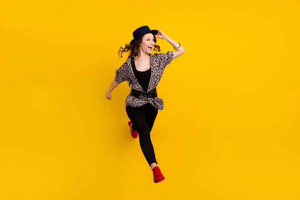 Full length φωτογραφία της γοητευτικής νεαρή ευτυχισμένη γυναίκα εξετάσουμε κενό χώρο άλμα απομονωμένο σε κίτρινο χρώμα φόντο — Φωτογραφία Αρχείου