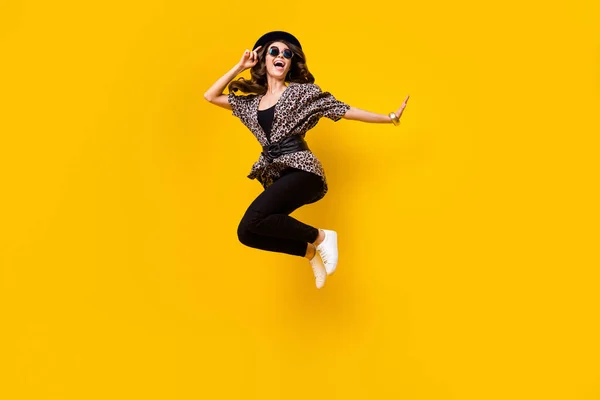 Foto av galen funky ung kvinna hoppa upp ser tomt utrymme bära svart hatt isolerad på gul färg bakgrund — Stockfoto