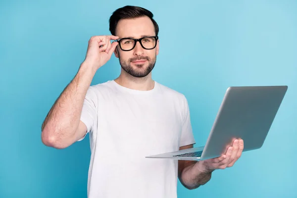 Retrato de la persona satisfecha mano tacto gafas mirada cámara mantenga portátil aislado sobre fondo de color azul — Foto de Stock