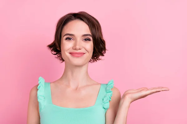 Retrato de menina alegre atraente segurando em palma cópia espaço espaço em branco anúncio solução isolada sobre cor pastel rosa fundo — Fotografia de Stock