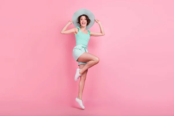 Foto de comprimento total de bonito curto penteado jovem senhora salto desgaste teal top shorts chapéu isolado no fundo cor-de-rosa — Fotografia de Stock
