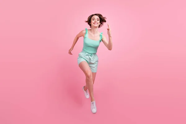 全长体形吸引人的快乐女孩跳跃快速跑过粉红的彩色背景 — 图库照片