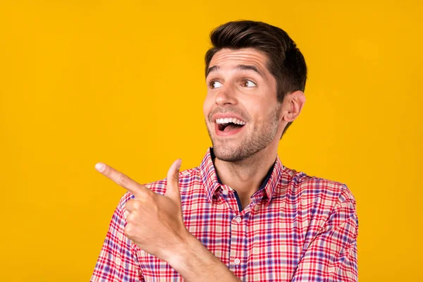 Портрет привабливого здивованого веселого хлопця, що демонструє копію порожньої реклами простору, ізольованої на яскраво-жовтому кольоровому фоні — стокове фото