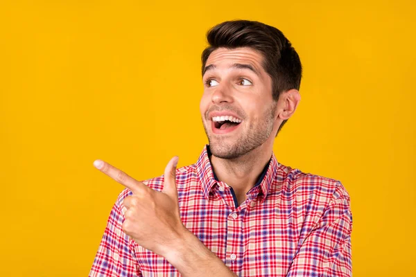 Retrato de atraente cara alegre surpreso demonstrando cópia anúncio espaço vazio isolado sobre fundo de cor amarelo brilhante — Fotografia de Stock