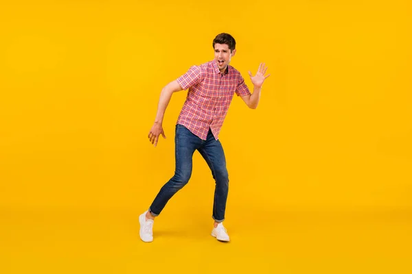 Foto de cuerpo entero de feliz hombre alegre positivo mirar vacío espacio danza aislado sobre fondo de color amarillo — Foto de Stock