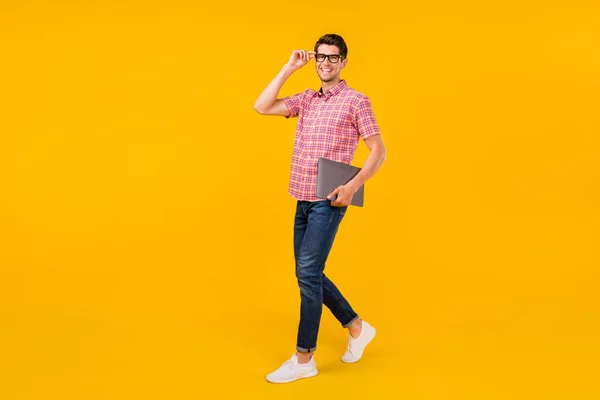 Volledige lengte lichaamsomvang uitzicht van aantrekkelijke bekwame vrolijke kerel gaan dragen laptop geïsoleerd over helder gele kleur achtergrond — Stockfoto