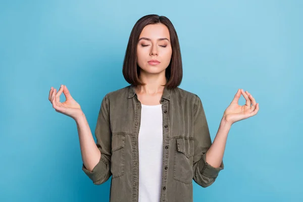 Fotografie zaostřená dáma meditovat úlovek zen symbol nosit khaki šedý outfit izolované přes modré barvy pozadí — Stock fotografie