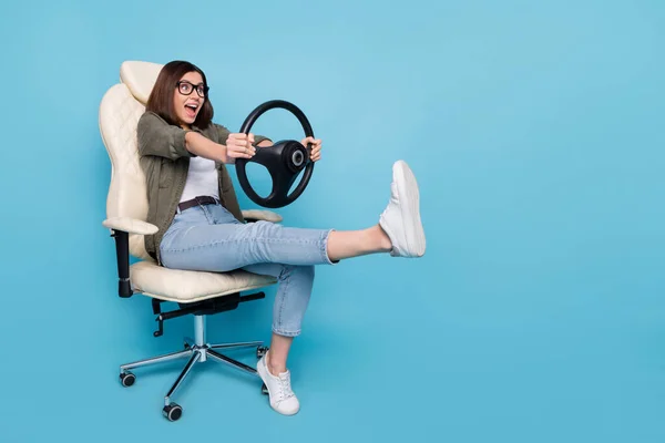 Foto de longitud completa de la señora sentarse silla mantener el volante paseo rápido tráfico desgaste ropa caqui aislado sobre fondo de color azul —  Fotos de Stock