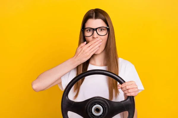 Foto de sorprendida mujer joven cubierta mano cara mantenga volante aislado sobre fondo de color amarillo —  Fotos de Stock