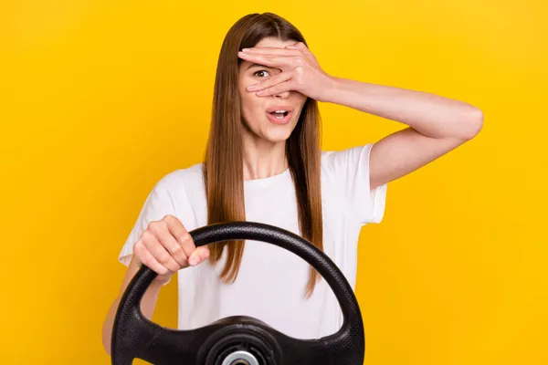 年轻的积极快乐的女人拿着方向盘的照片学生司机用黄色的背景偷看眼睛盖住手 — 图库照片