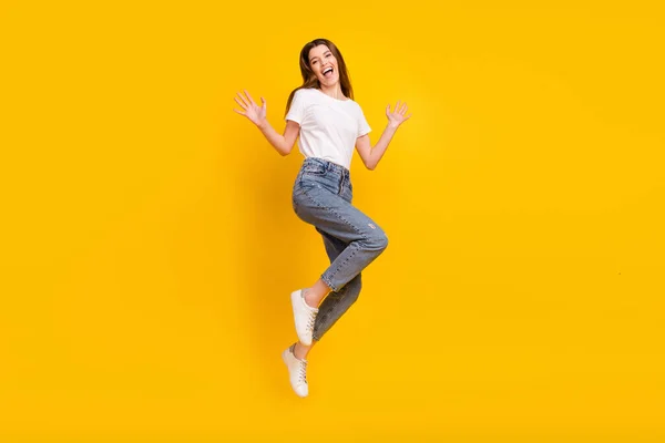 Foto em tamanho completo de mulher feliz animado positivo pular mãos bom humor isolado no fundo de cor amarela — Fotografia de Stock