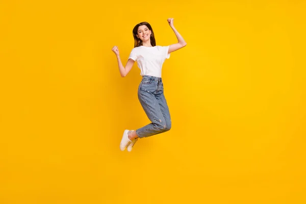 Фотографія повного тіла веселого молодої щасливої жінки, що стрибає вгору, святкують ізольовано на жовтому кольорі — стокове фото