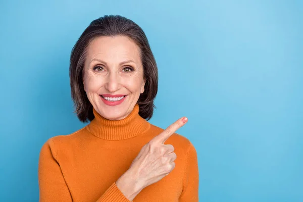 Portrait of satisfied glad person indicate finger empty space offer proposition isolated on blue color background — Stockfoto
