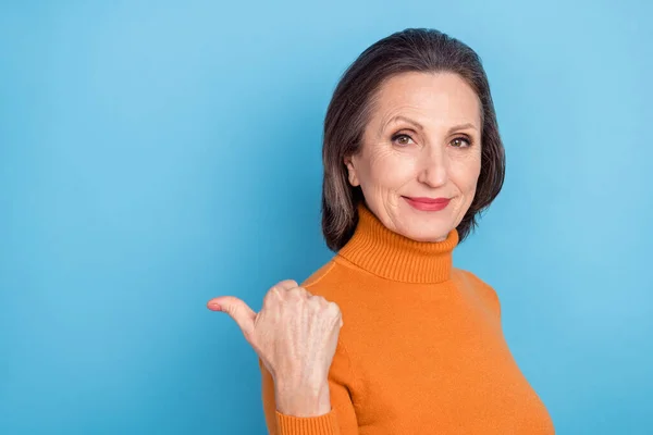 Profilfoto von ruhigen ziemlich alten Person direkt Daumenfinger leeren Raum suchen Kamera isoliert auf blauem Hintergrund — Stockfoto