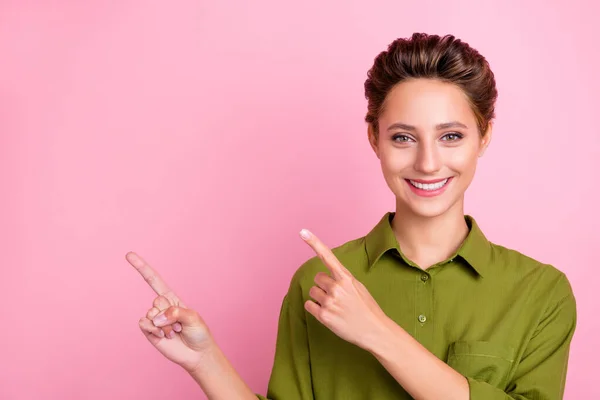 Foto de divertida encantadora joven dama usar blusa verde señalando los dedos espacio vacío aislado color rosa fondo —  Fotos de Stock