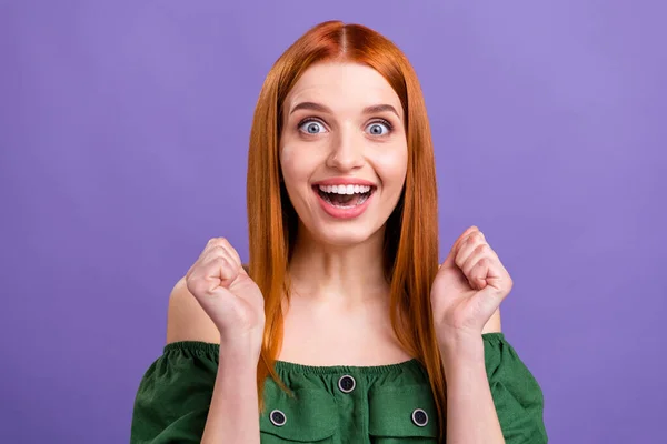 Фото смішної щасливої молодої леді в зеленій блузці великі очі відкриті рот піднімаються кулаки ізольовані фіолетовий кольоровий фон — стокове фото