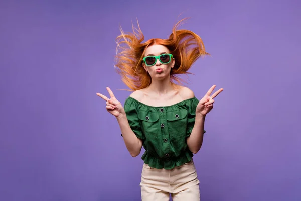 Foto van schattige flirterige jonge dame dragen groene blouse tonen v-tekens sturen u kus geïsoleerde paarse kleur achtergrond — Stockfoto