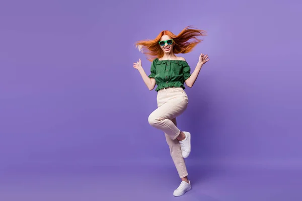 Photo of excited pretty young woman dressed off-shoulders blouse dark eyewear dancing smiling isolated violet color background — 图库照片