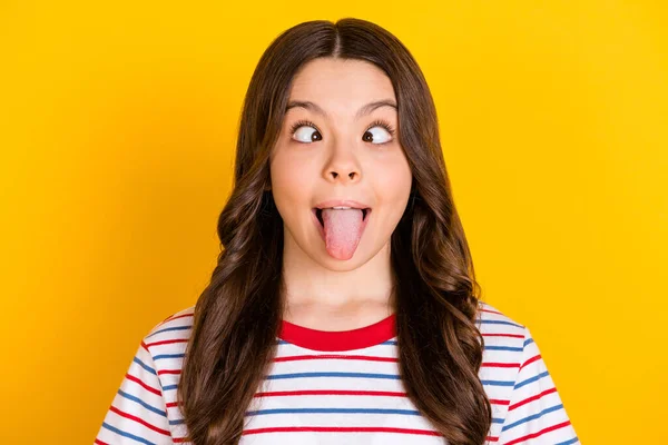 照片上年轻时髦滑稽的疯狂小女孩 带着滑稽的舌头 带着滑稽的幽默 在黄色背景下被隔离 — 图库照片