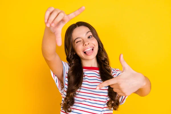 Foto de joven feliz alegre sonriente funky divertida chica tomando foto mostrando la lengua aislada en el fondo de color amarillo — Foto de Stock