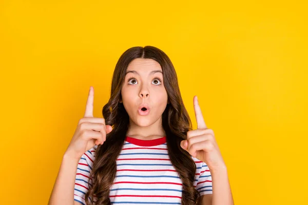 Photo of young excited girl look indicate fingers up advert direct way suggest advice isolated over yellow color background — Stockfoto