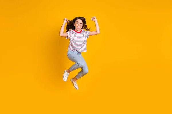 Full length φωτογραφία του νεαρού κοριτσιού ευτυχισμένη γιορτάσουν νίκη νίκη τυχερή επιτυχία γροθιές άλμα χέρια απομονώνονται πάνω από κίτρινο χρώμα φόντο — Φωτογραφία Αρχείου