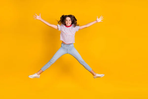 Foto de corpo inteiro de menina alegre feliz sorriso positivo se divertir saltar isolado sobre fundo de cor amarela — Fotografia de Stock