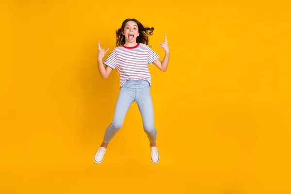 Full body foto van jong meisje springen grimas tong-out tonen vinger steen teken gek geïsoleerd over gele kleur achtergrond — Stockfoto