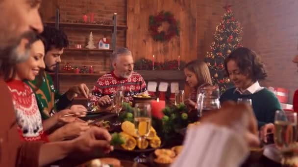 Адвент концепция семейного собрания сидеть за столом насладиться вкусной рождественской кухни — стоковое видео