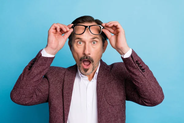 Photo of shocked crazy chief man wow face open mouth wear eyeglasses red blazer isolated blue color background.