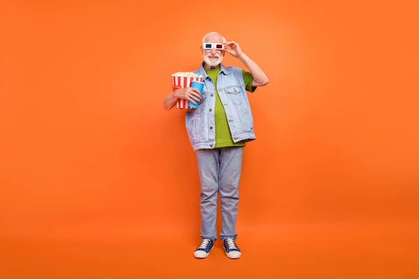 Foto von süßen schönen Rentner tragen Jeans Weste 3D-Brille essen Popcorn trinken Getränk isoliert orange Farbe Hintergrund — Stockfoto