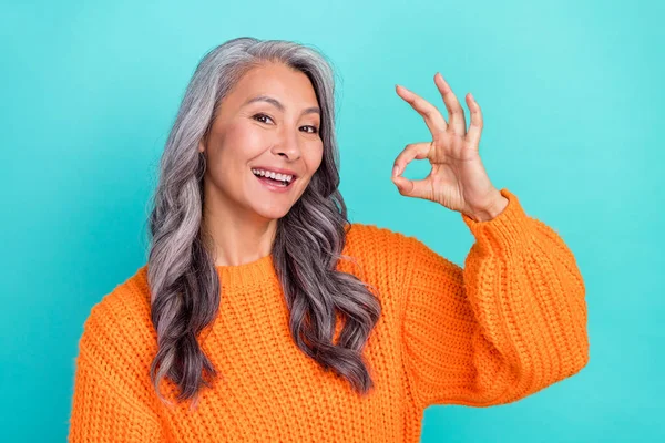 Retrato de atractiva mujer de pelo gris alegre mostrando consejo ok-signo anuncio perfecto aislado sobre fondo de color turquesa brillante verde azulado —  Fotos de Stock