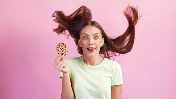 Τρελή πεινασμένη αστεία χαριτωμένη κυρία κρατά νόστιμο μπισκότο σοκολάτας γλείφει δελεαστικά χείλη — Αρχείο Βίντεο