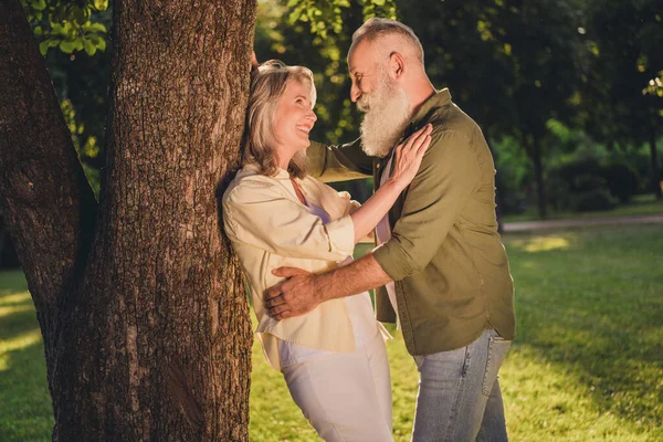 Foto del lado del perfil de pareja mayor cita romántica historia de amor abrazo abrazo bosque de madera naturaleza primavera al aire libre — Foto de Stock