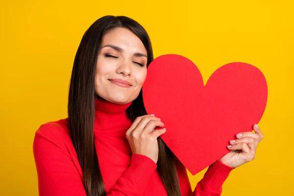 Retrato de adorável senhora satisfeito fechado olhos segurar abraço coração cartão postal isolado no fundo cor amarela — Fotografia de Stock