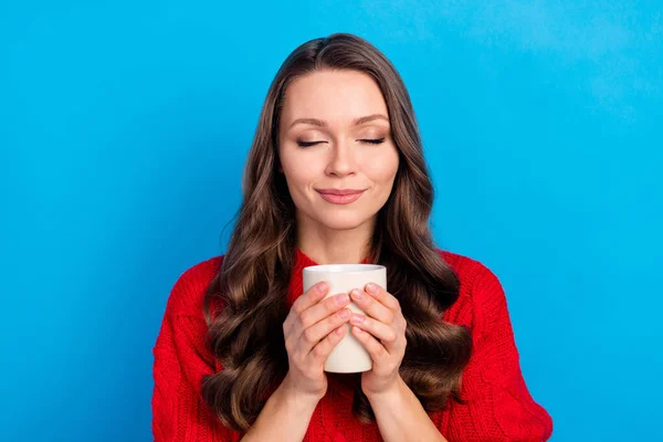 Retrato de menina alegre sonhadora atraente bebendo bebida quente isolada sobre fundo de cor azul brilhante — Fotografia de Stock