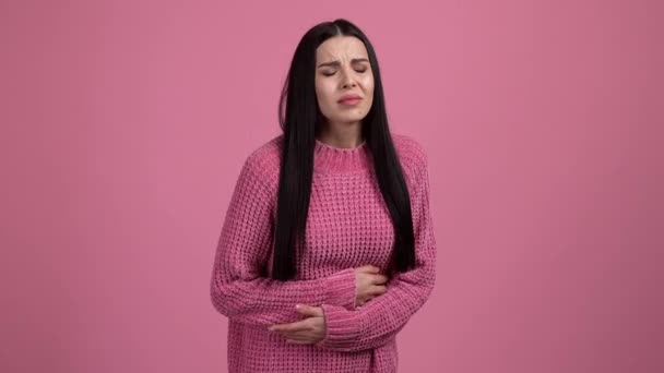 Senhora sofrer forte dor de barriga isolado pastel cor de fundo rosa — Vídeo de Stock