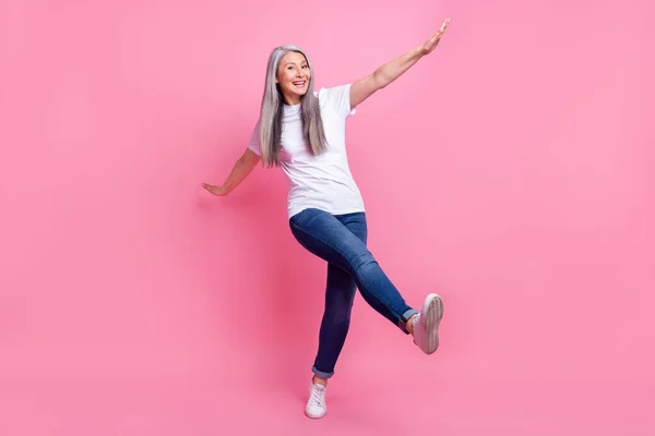 전체 몸길이의 여자 춤의 사진 행복하게 티셔츠 청바지를 입고 분리 된 파스텔 핑크 색 배경 — 스톡 사진