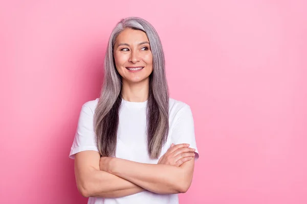 Foto portret van senior zakenvrouw glimlachen met gevouwen handen op zoek naar lege ruimte geïsoleerde pastel roze kleur achtergrond — Stockfoto