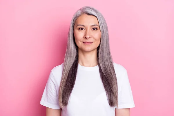 Foto retrato de la anciana sonriendo en camiseta blanca aislada sobre fondo de color rosa pastel —  Fotos de Stock