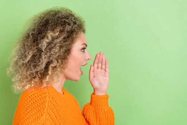 Профиль фото смешной молодой блондинки рассказать секрет носить оранжевый свитер изолированы на зеленом фоне — стоковое фото